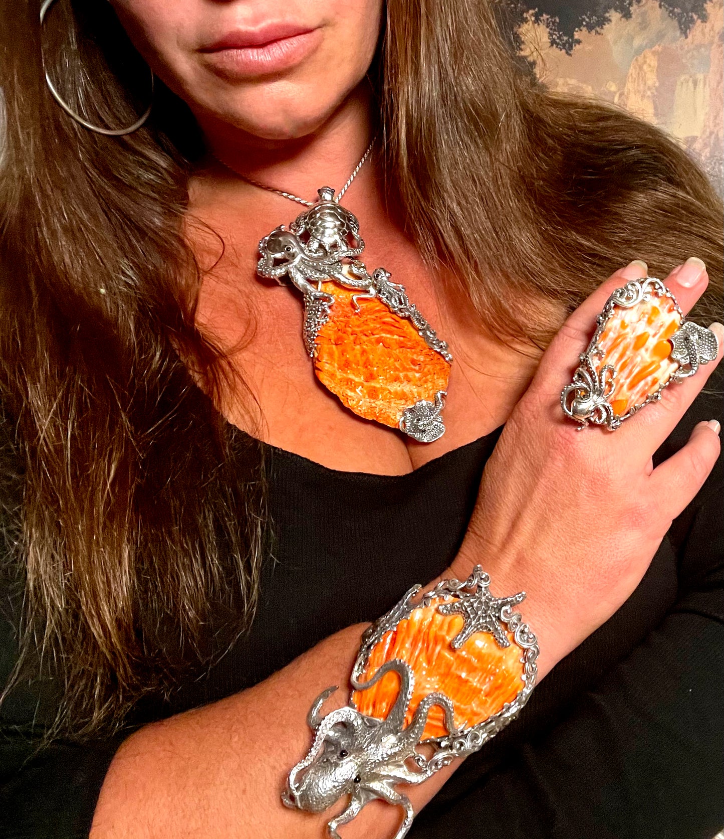 
                  
                    A woman wearing an orange Handcrafted Spiny Shell Designer ring and bracelet, inspired by the ocean.
                  
                