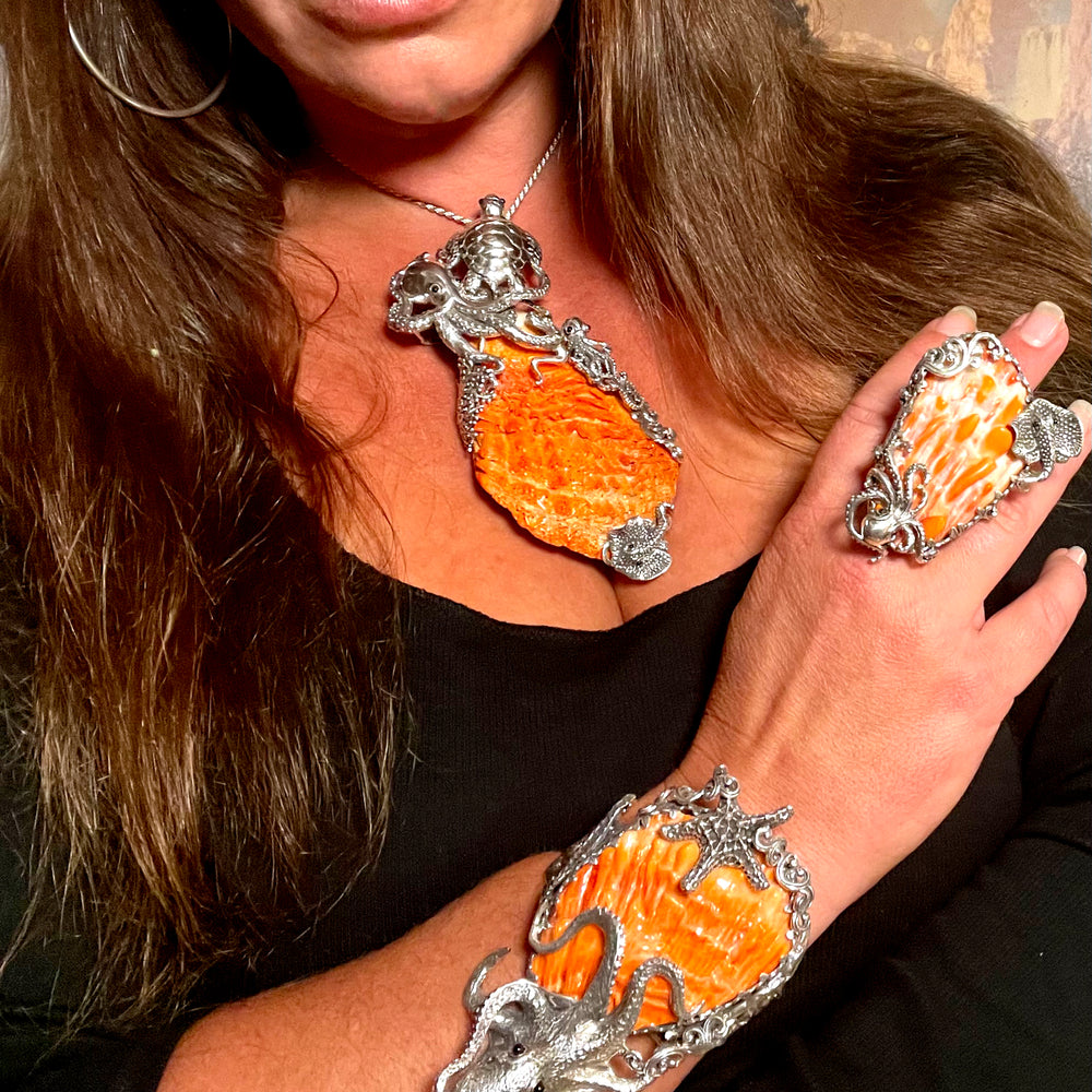 A woman wearing an orange octopus ring with a Super Silver Handcrafted Spiny Shell Designer Cuff Bracelet.