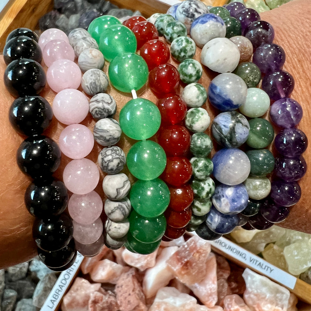 A woman's wrist adorned with a variety of Super Silver's Beaded Stone Bracelets.