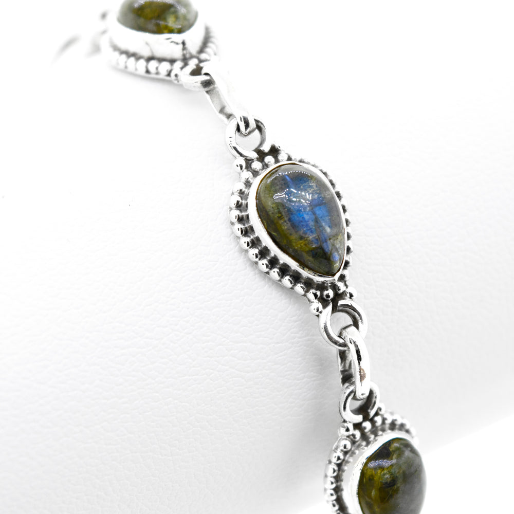 A vibrant silver Super Silver bracelet adorned with teardrop-shaped blue labradorite stones.