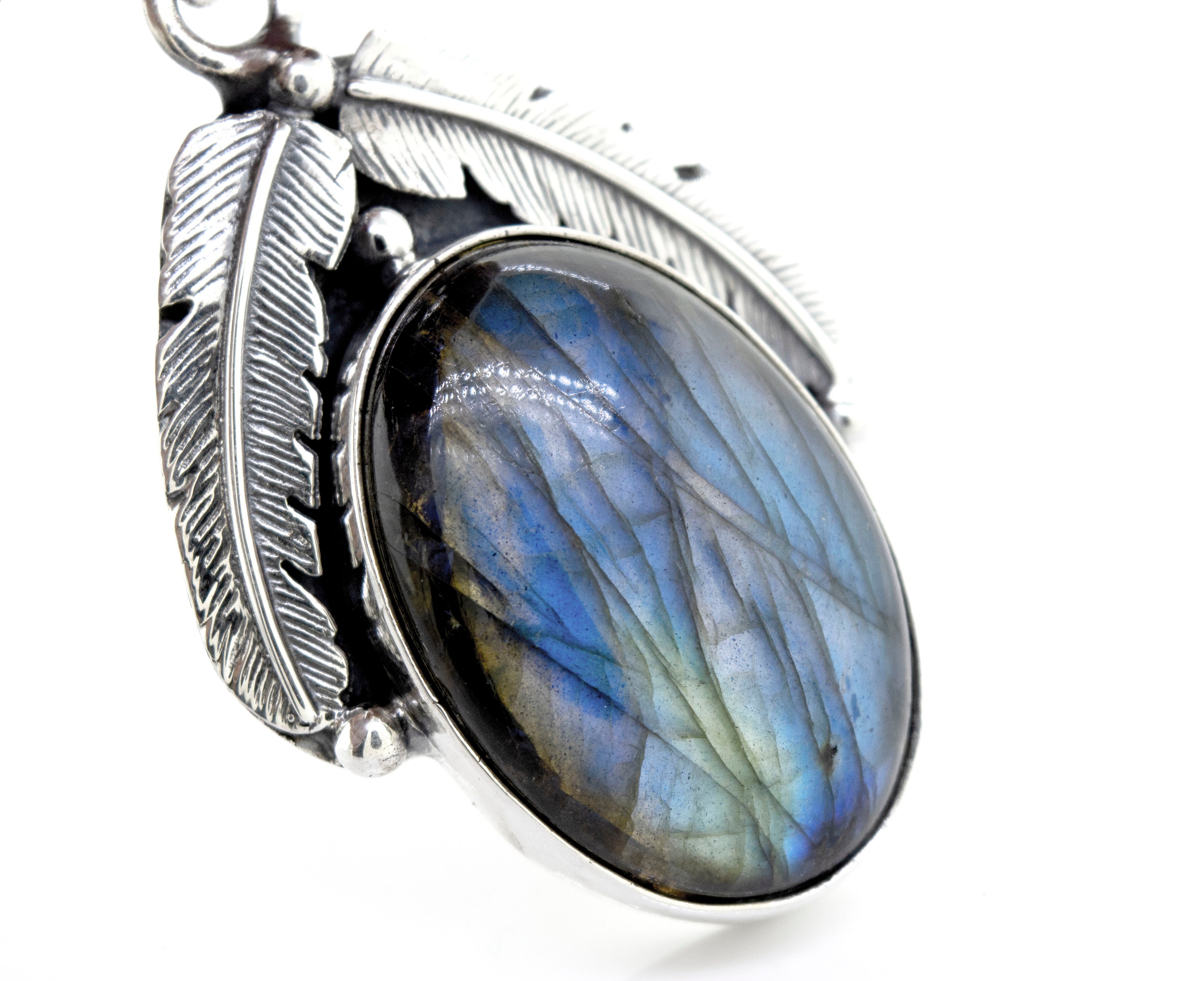 Close-up of a Beautiful Southwest Stone Pendant set in sterling silver adorned with detailed feather motifs.