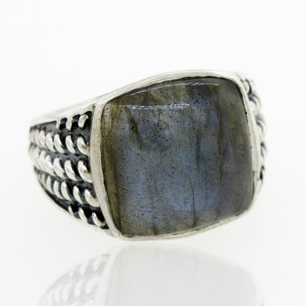 
                  
                    A minimalist sterling silver labradorite signet ring with a rope design.
                  
                