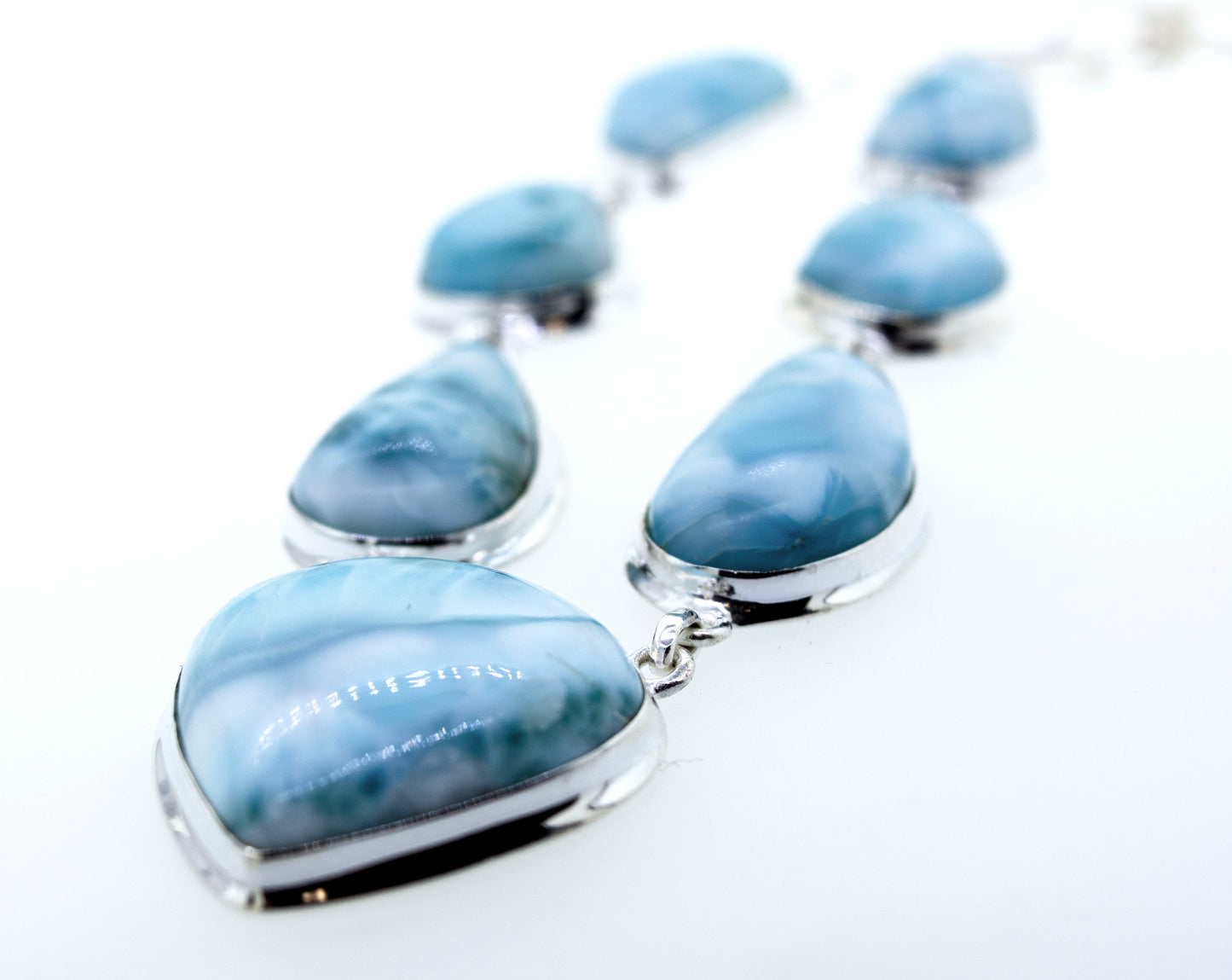 A Super Silver Larimar Necklace adorned with raw natural larimar stones on a white surface.