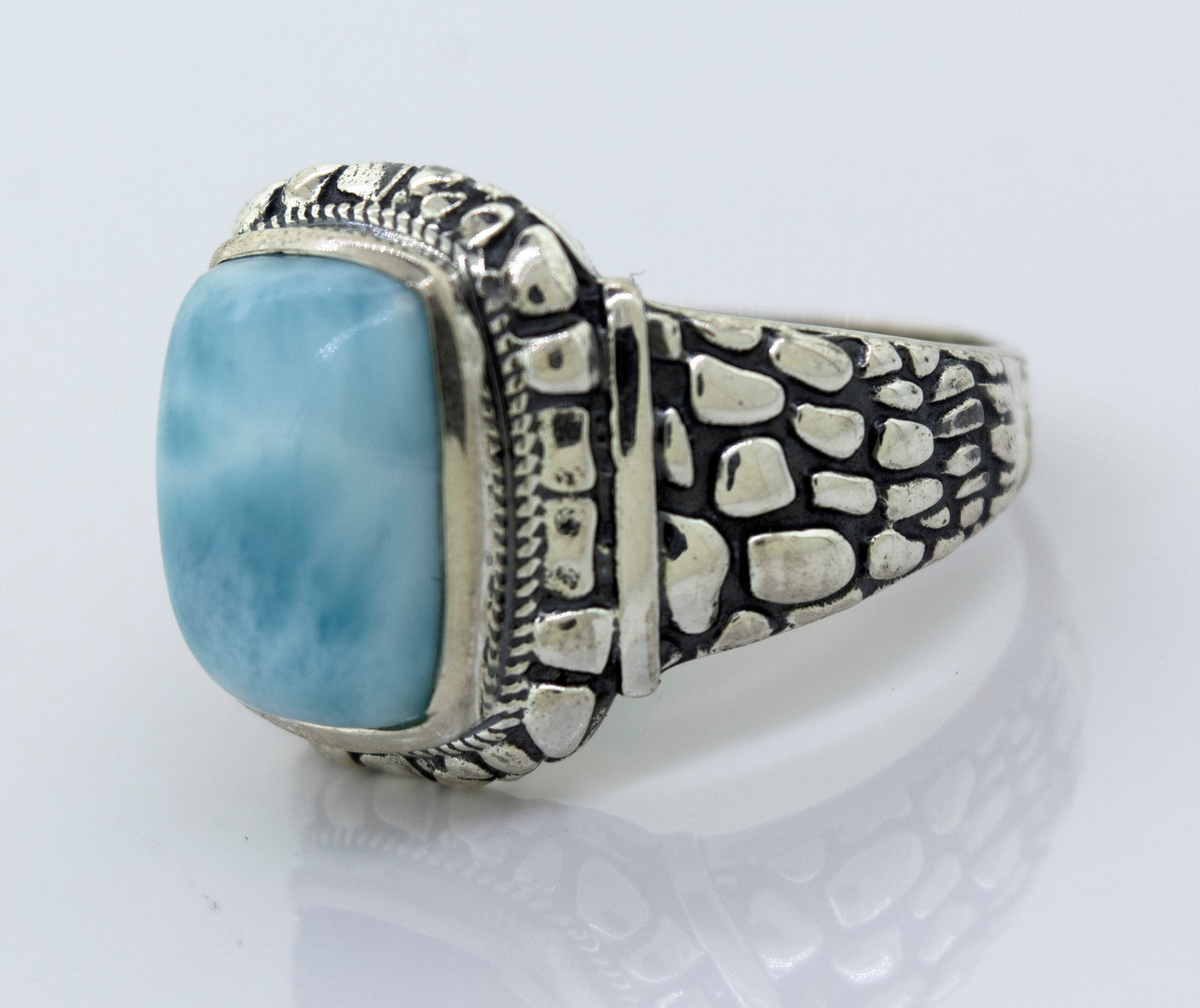 
                  
                    A minimalist Larimar Signet Ring With Dragon Scale Pattern with a large blue stone.
                  
                