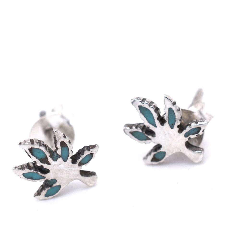 A pair of Super Silver turquoise leaf stud earrings featuring a subtle marijuana leaf design.