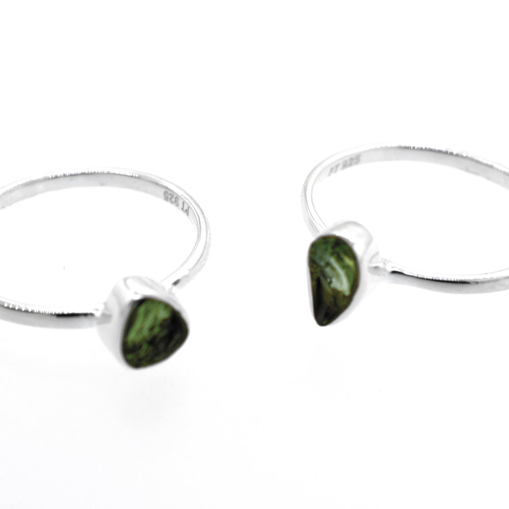 
                  
                    A pair of Super Silver raw moldavite rings.
                  
                
