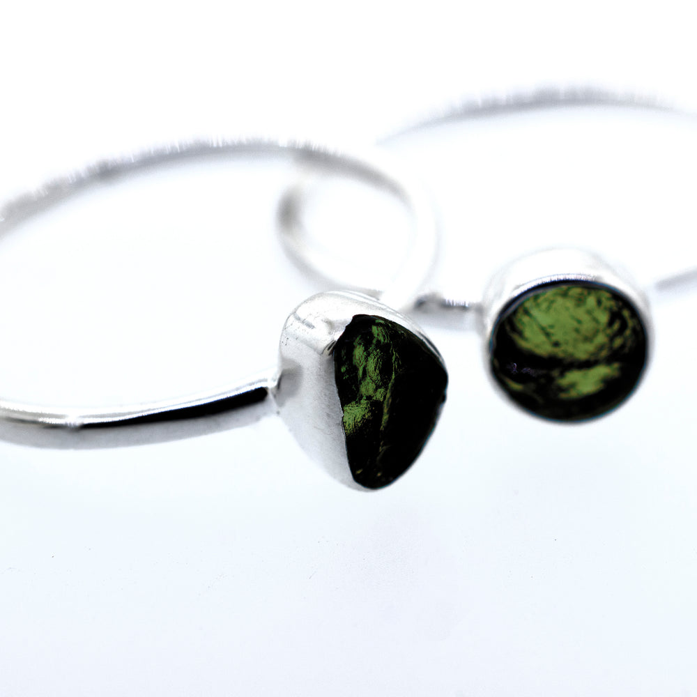 
                  
                    A pair of Super Silver sterling silver rings with green peridot stones and a sterling silver setting.
                  
                