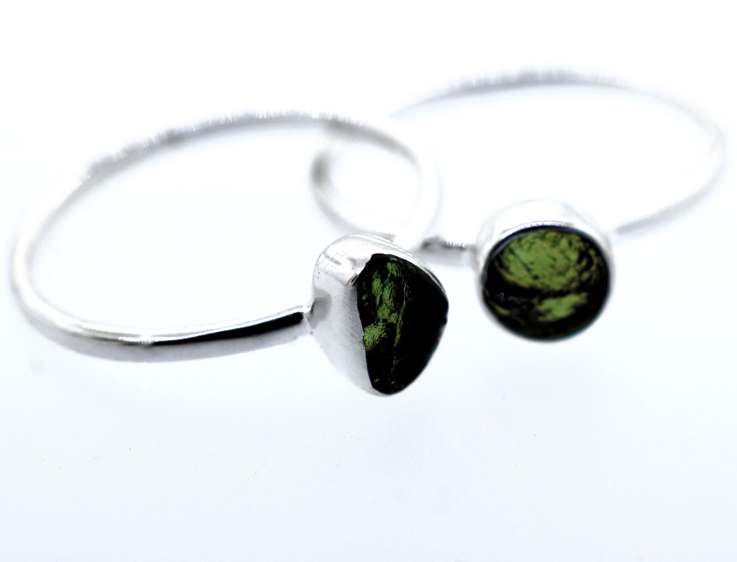 
                  
                    A pair of Super Silver sterling silver rings with green peridot stones and a sterling silver setting.
                  
                