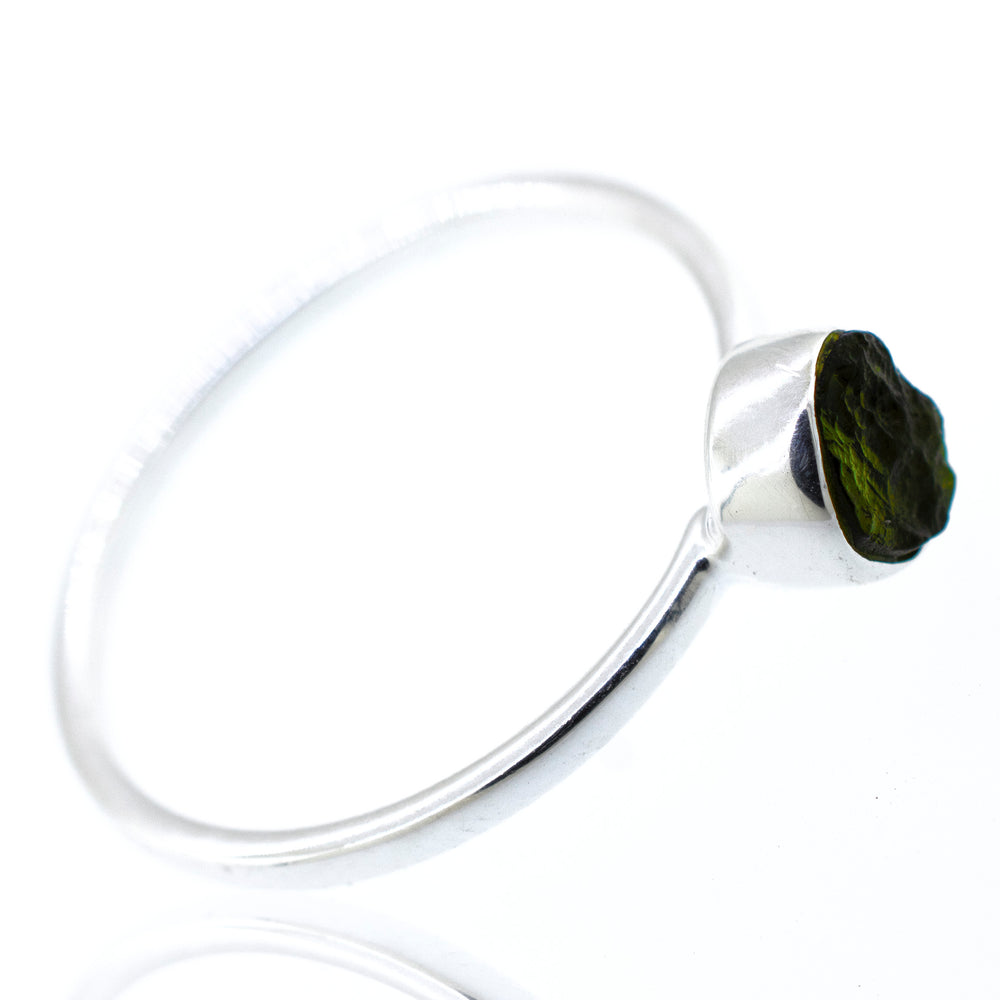 
                  
                    A Super Silver raw moldavite ring, with a green stone, featuring a raw moldavite set in a sterling silver setting.
                  
                