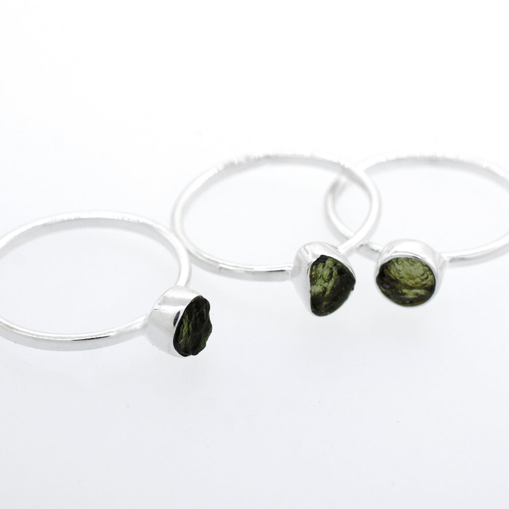
                  
                    Three Super Silver raw moldavite rings with green tourmaline stones and a sterling silver setting.
                  
                