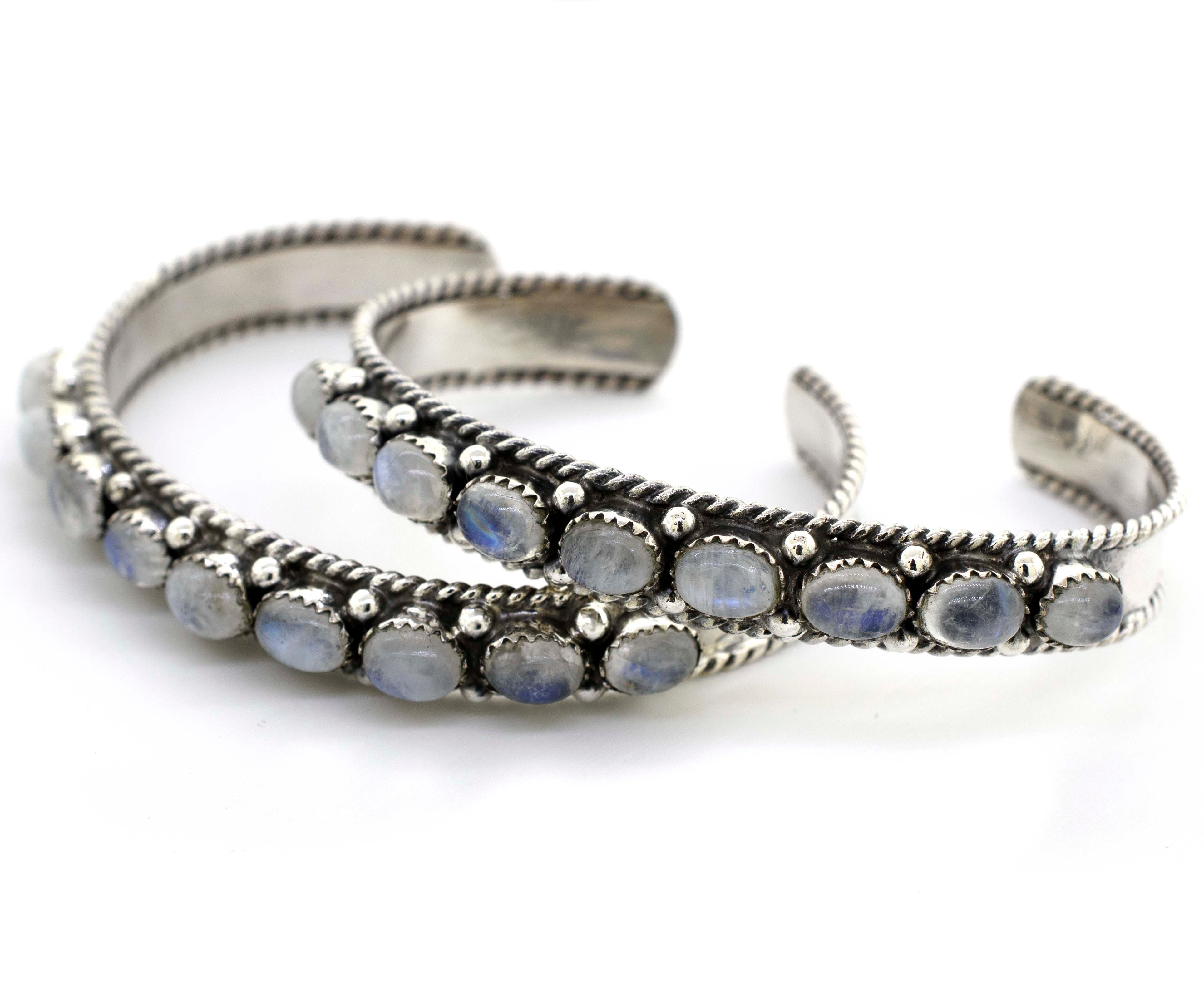 A pair of Super Silver Oval Moonstone Cuff Bracelets, adorned with captivating blue stones, taking wearers on a celestial journey.