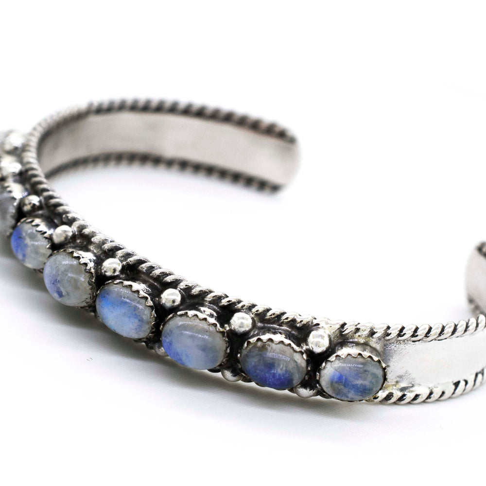 
                  
                    A Super Silver Oval Moonstone Cuff Bracelet adorned with blue stones will take you on a celestial journey.
                  
                