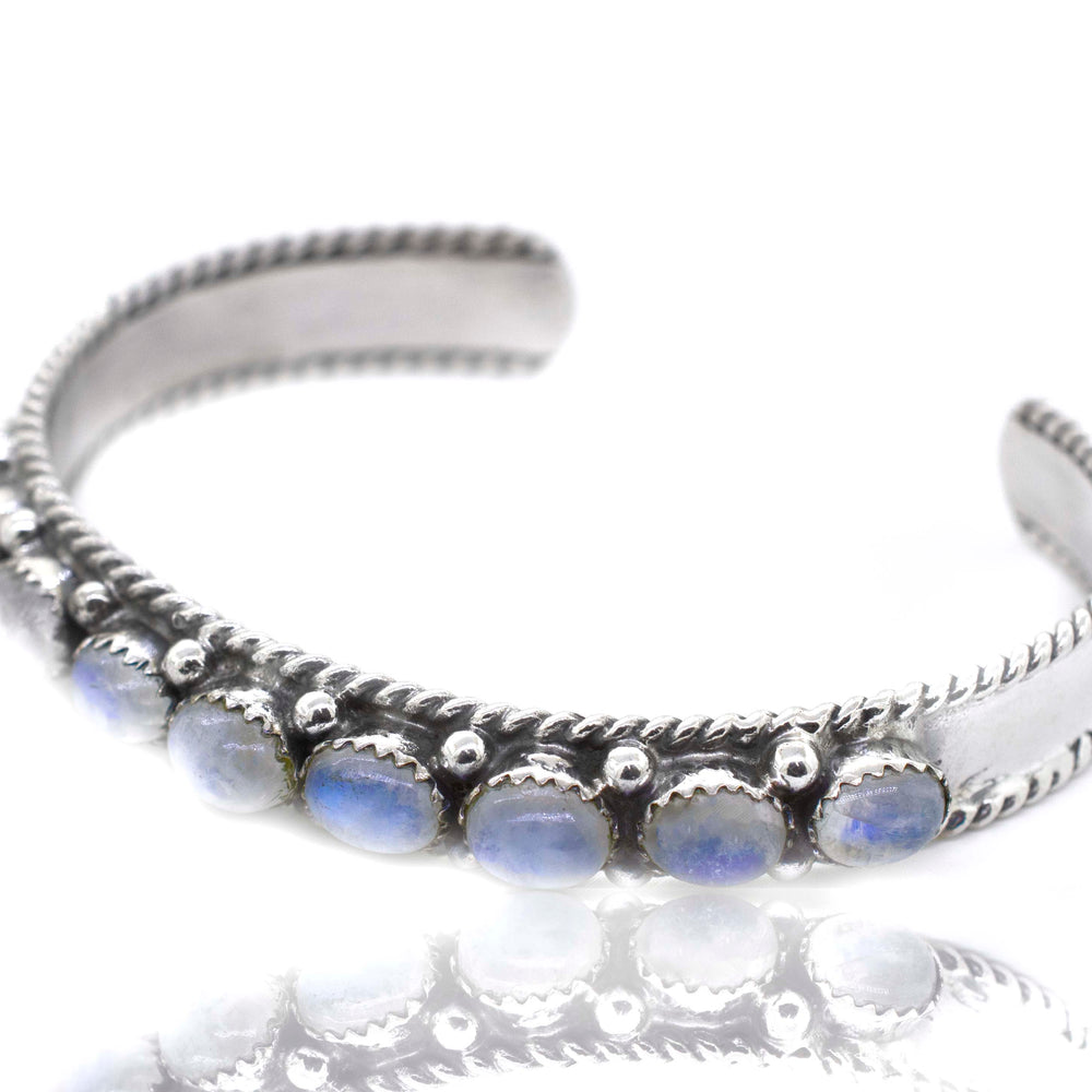 
                  
                    A Super Silver Oval Moonstone Cuff Bracelet adorned with moonstone and sparkling blue stones.
                  
                
