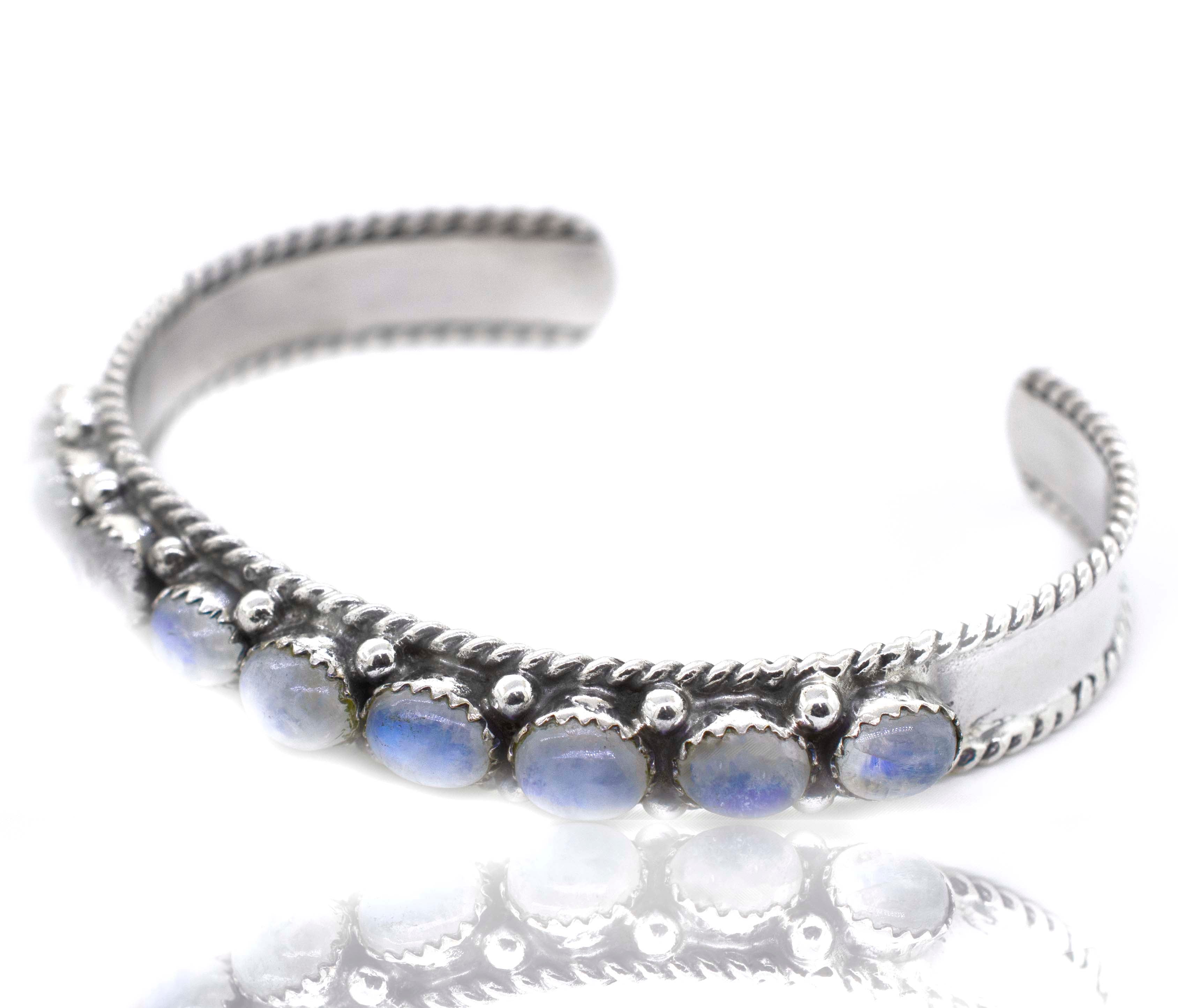A Super Silver Oval Moonstone Cuff Bracelet adorned with moonstone and sparkling blue stones.