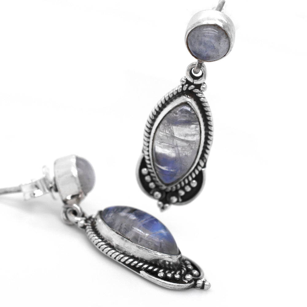 A pair of Super Silver's Captivating Moonstone Earrings with a blue moonstone in an oxidized rope setting.