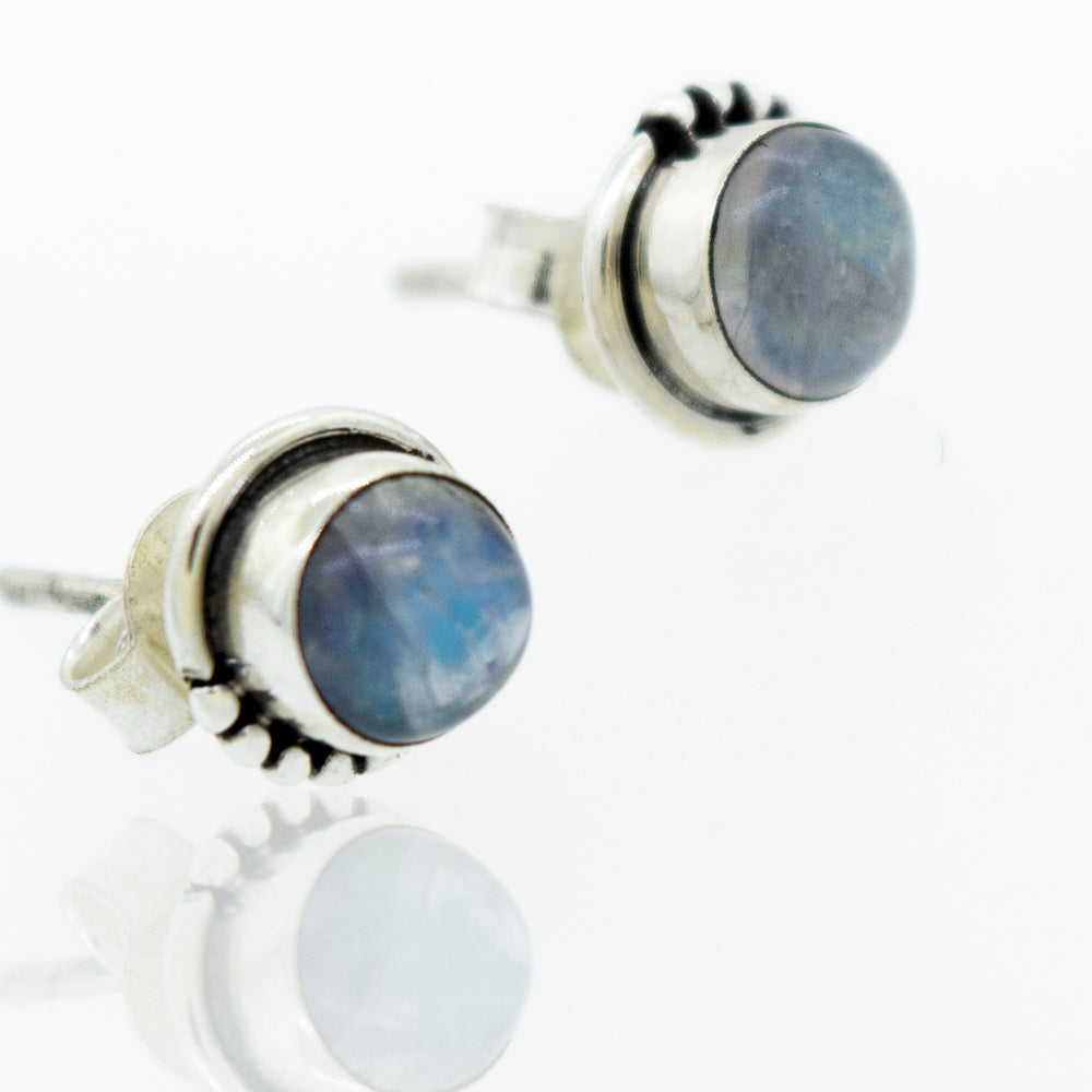 A pair of Super Silver Small Moonstone Studs with Ball Border earrings with a dainty 7mm blue stone.