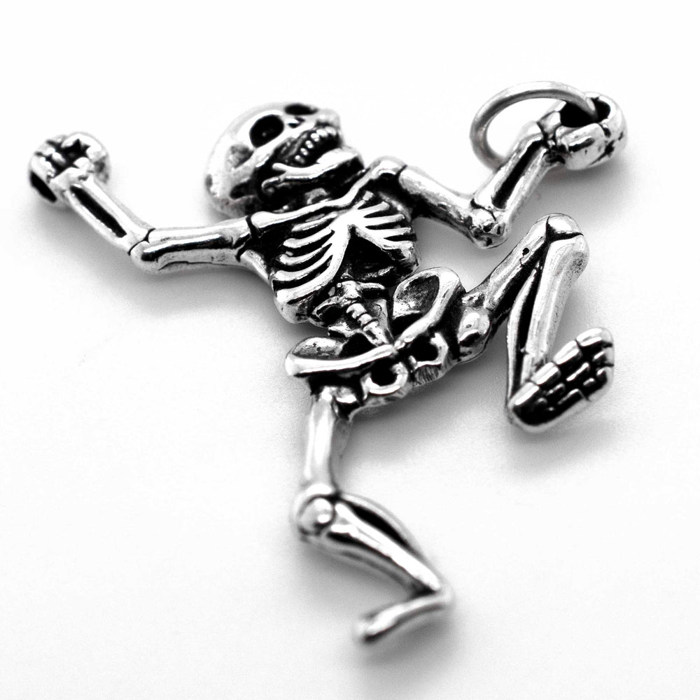 A Dancing Skeleton Pendant charm pendant on a white surface from Super Silver.