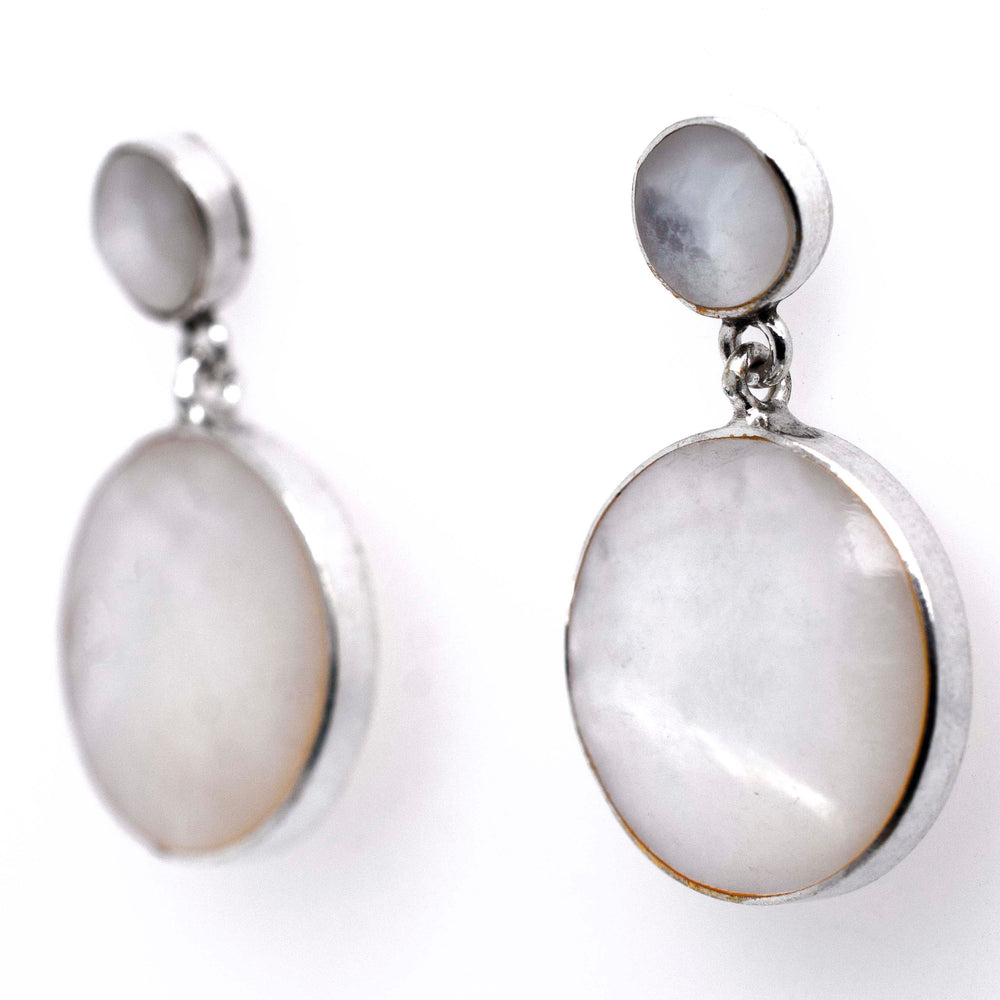 
                  
                    A pair of Super Silver Round Mother Of Pearl earrings showcasing exquisite refinement on a timeless white background.
                  
                