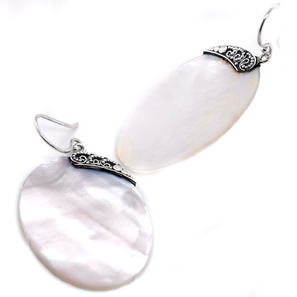 A pair of Simple Mother Of Pearl Statement Earrings by Super Silver elegantly displayed on a white background.