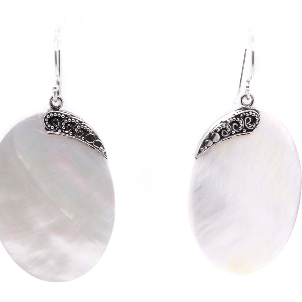 
                  
                    A pair of Simple Mother Of Pearl Statement Earrings adorned with intricate silverwork by Super Silver.
                  
                