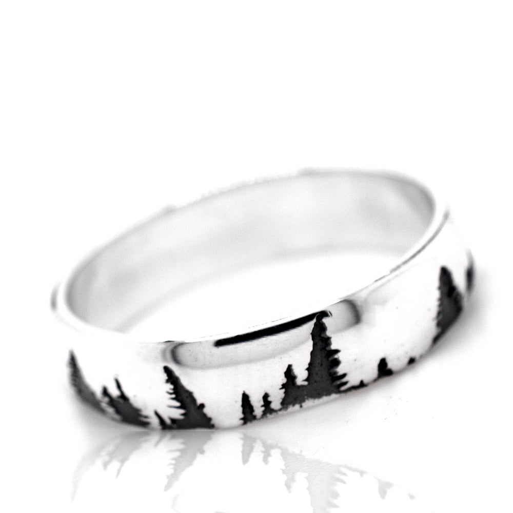 
                  
                    A nature-inspired sterling silver ring, the Sleek Tree Band, with trees in the background.
                  
                