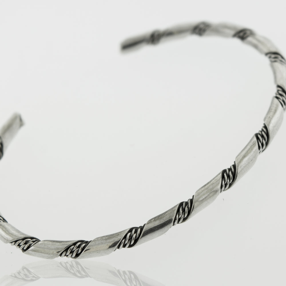 
                  
                    Addition: A stunning Native American Handmade Thin Silver Twist Cuff bracelet by Super Silver, perfect for adding a touch of elegance to any outfit.
                  
                