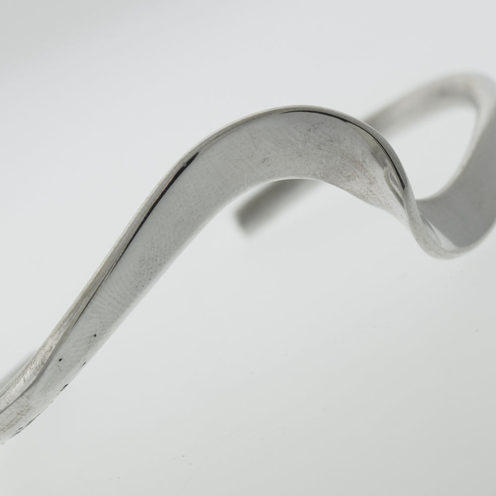 A simple Super Silver Native American Handmade Thick Silver Wave Cuff bracelet with a curved shape.