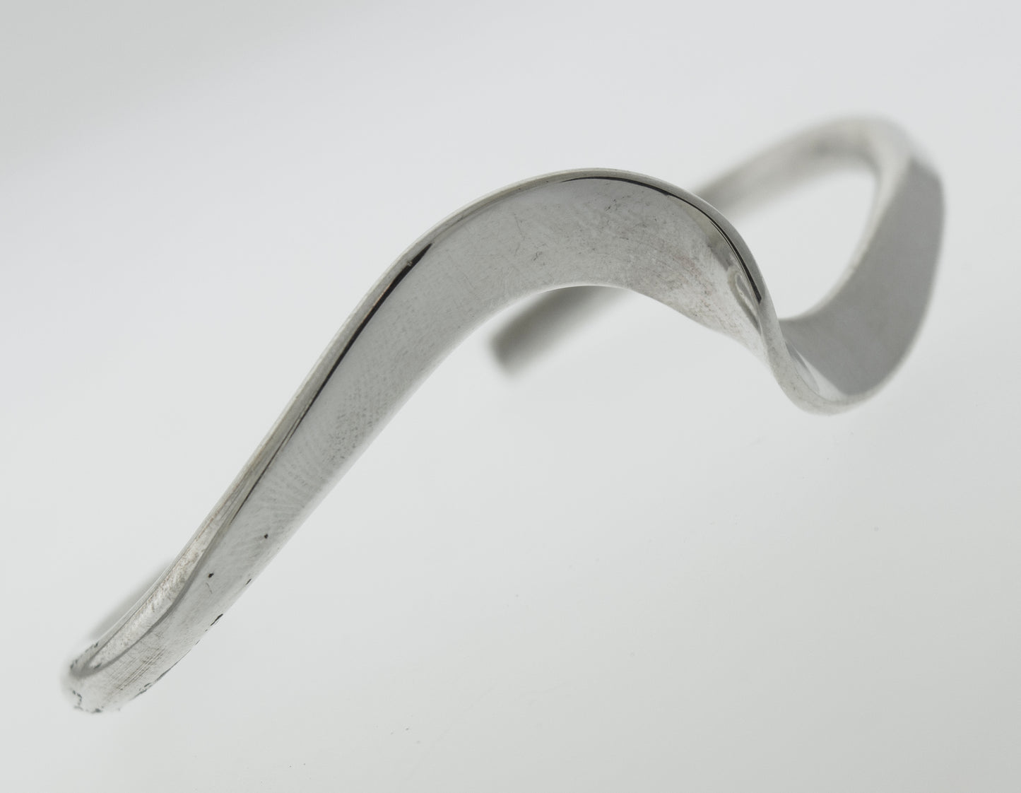 A simple Super Silver Native American Handmade Thick Silver Wave Cuff bracelet with a curved shape.