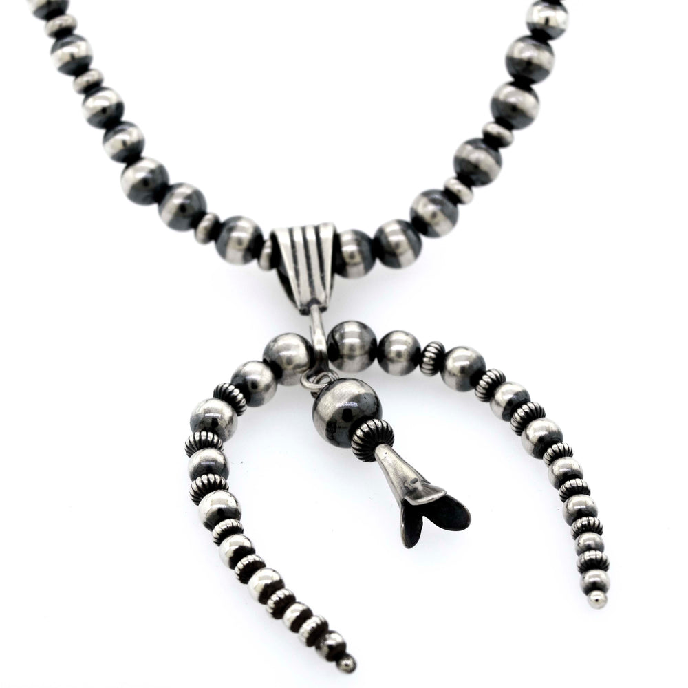 
                  
                    A Super Silver Handcrafted Naja Beaded Necklace adorned with black and white Navajo pearls, offering a sense of protection.
                  
                