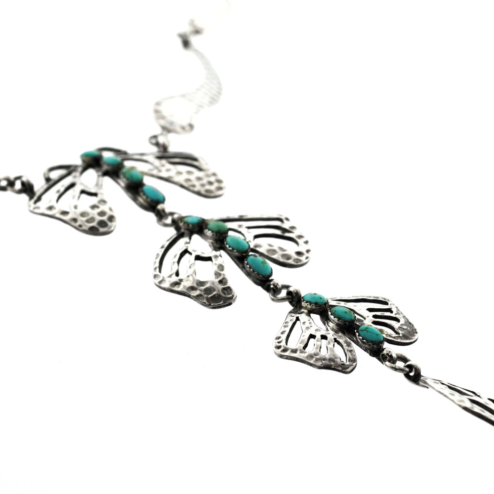 
                  
                    A Super Silver Handmade Turquoise Dragonfly Necklace And Earring Set adorned with turquoise beads and leaves.
                  
                