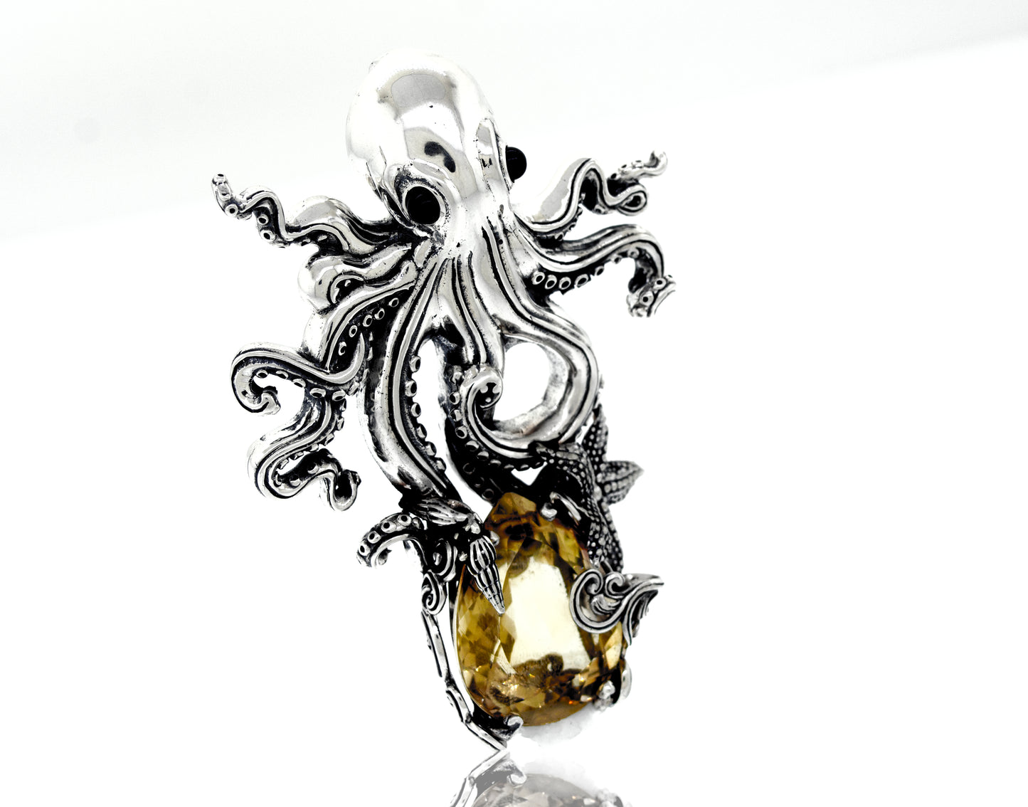 A Super Silver designer handmade octopus pendant with vibrant citrine crystal, featuring mesmerizing onyx eyes and a vibrant citrine stone.