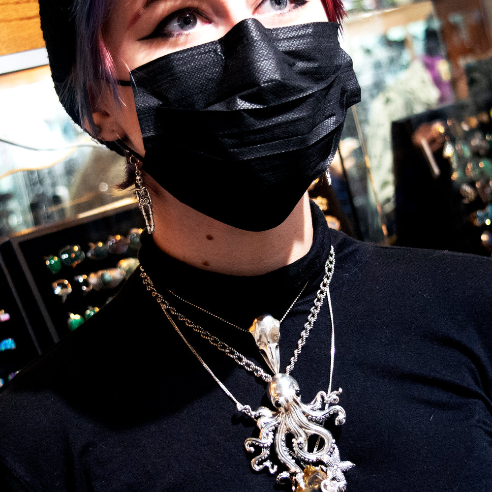 
                  
                    A woman wearing a Super Silver Designer Handmade Octopus Pendant With Vibrant Citrine Crystal mask in a jewelry store.
                  
                