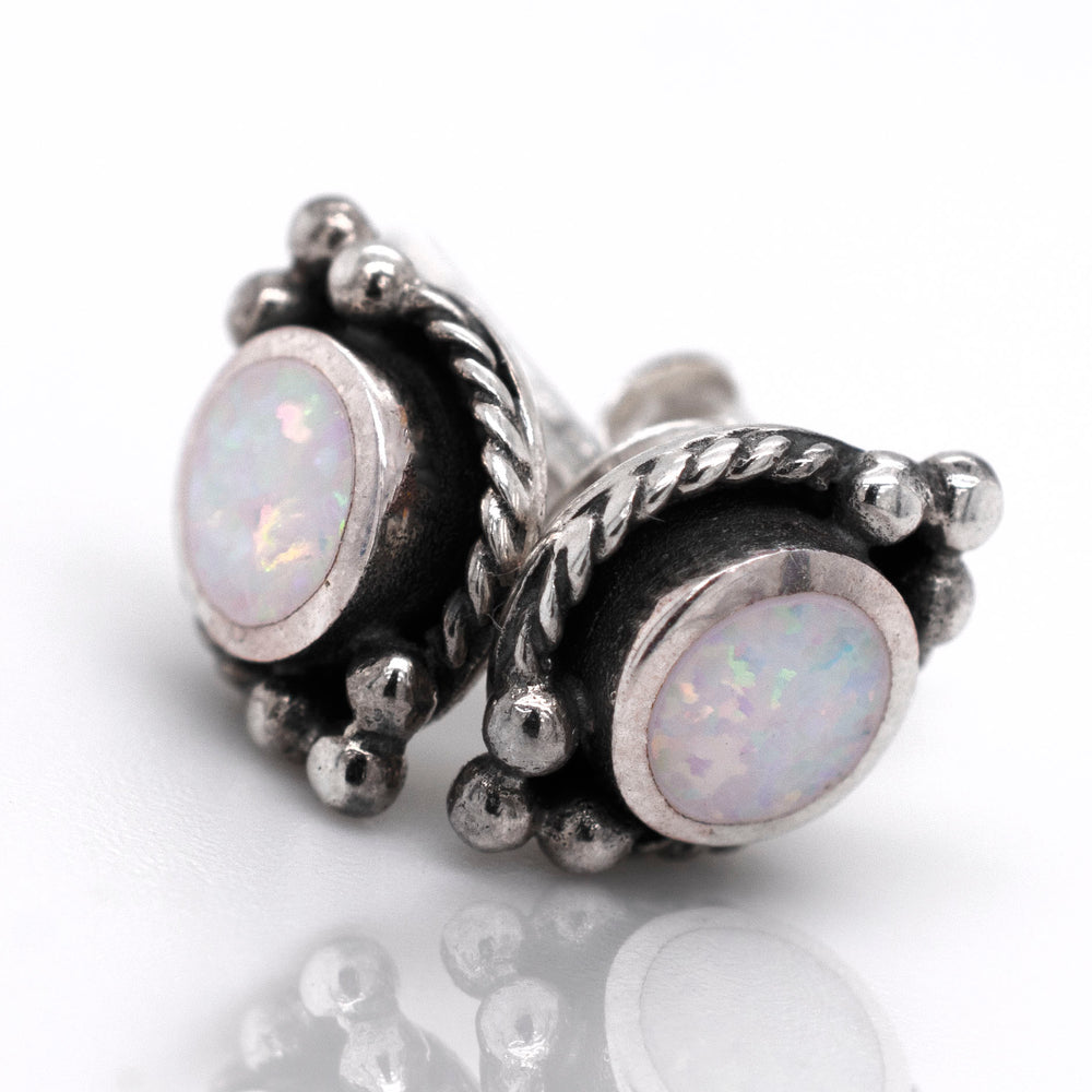 
                  
                    A pair of Super Silver Bali Style Opal Stud Earrings with oxidized rope detailing on a white surface.
                  
                
