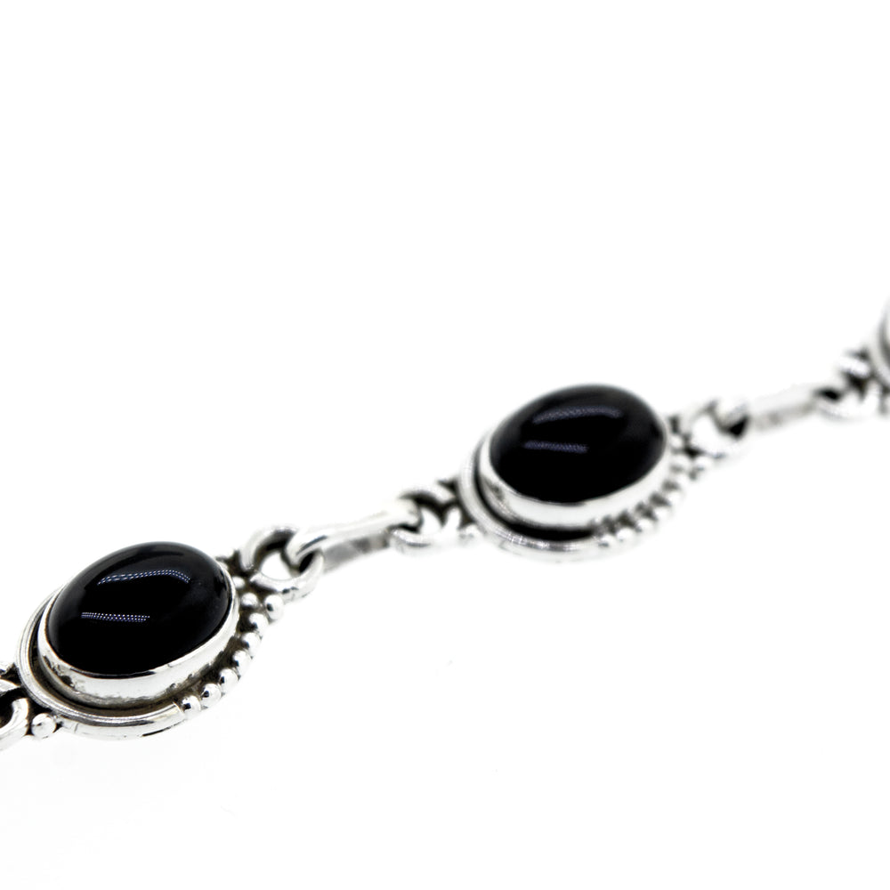 
                  
                    A bohemian chic Oval Gemstone Bracelet With Half Ball Border adorned with black onyx gemstone stones.
                  
                