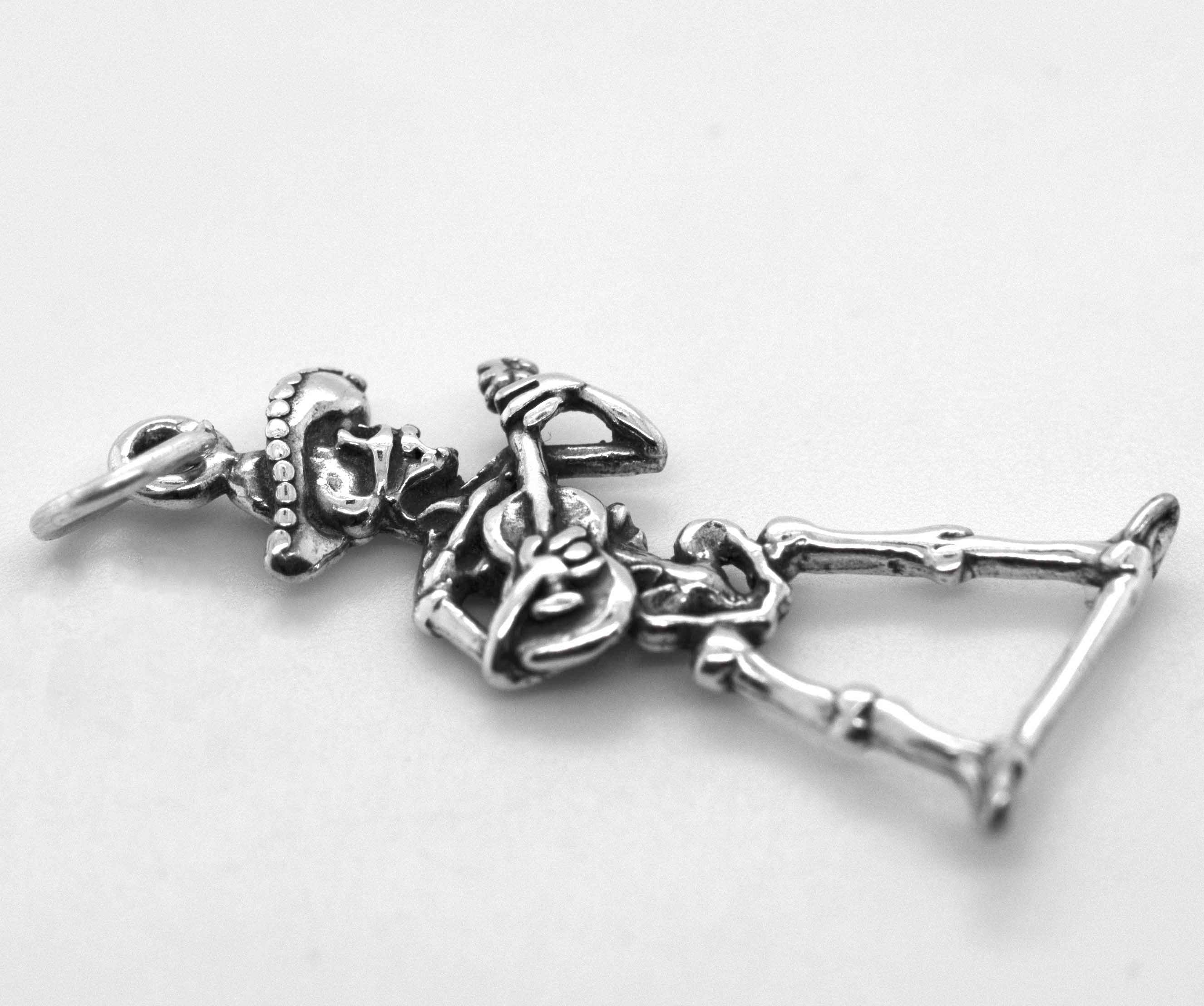 A Super Silver Mariachi Skeleton with Guitar Charm is sitting on a white surface.