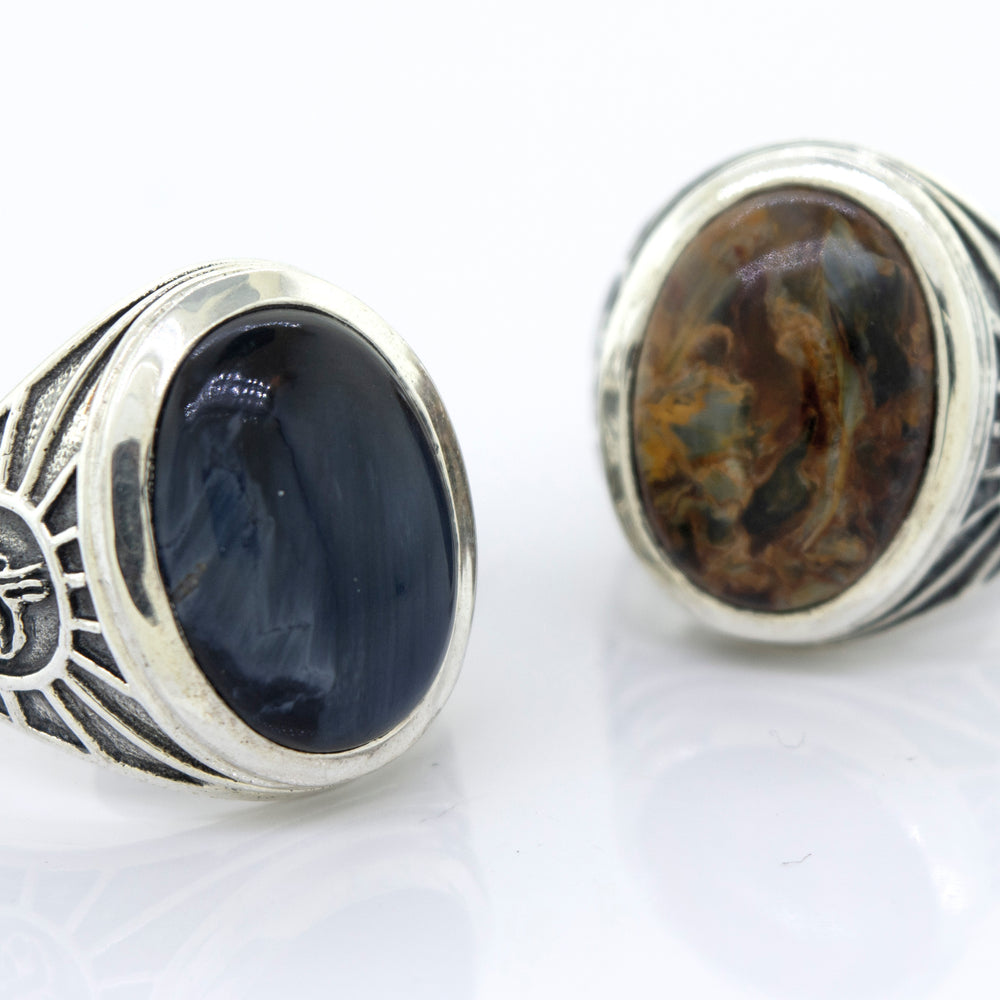 
                  
                    A minimalist Oval Pietersite signet ring with a blue and black stone.
                  
                
