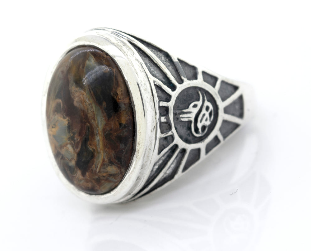 A minimalist Oval Pietersite Signet Ring With Wolf Symbol for men, featuring a silver band adorned with a black stone and an inscription.