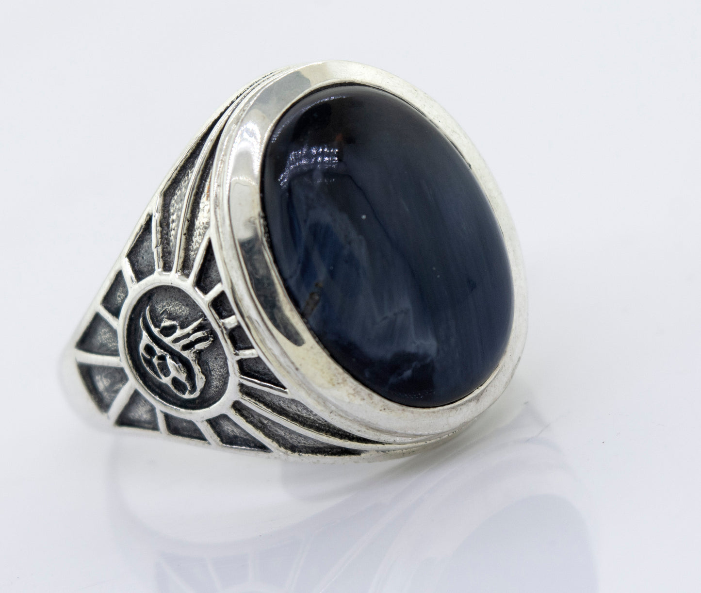 A minimalist Oval Pietersite signet ring with a blue stone.