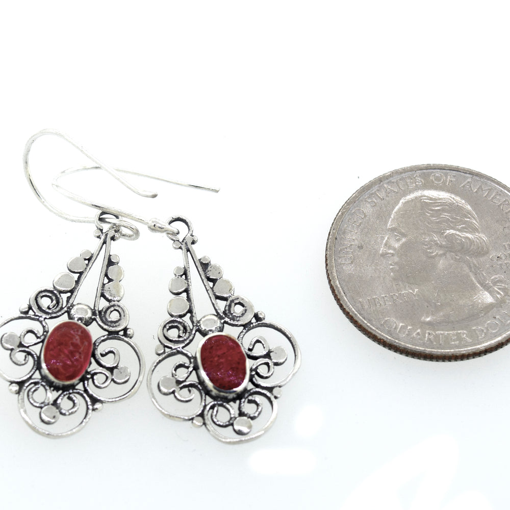 
                  
                    These vibrant Super Silver oval coral dangle earrings with a flower design feature a red stone.
                  
                