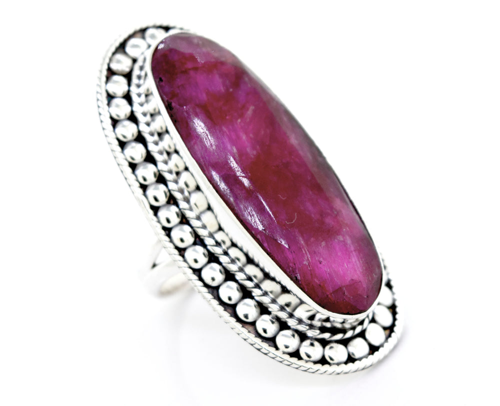 An Elegant Raw Ruby Ring from Super Silver with a pink stone in a silver setting.