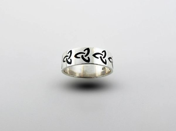 A Super Silver Celtic Trinity Knot Thick Band Ring with black and white designs.