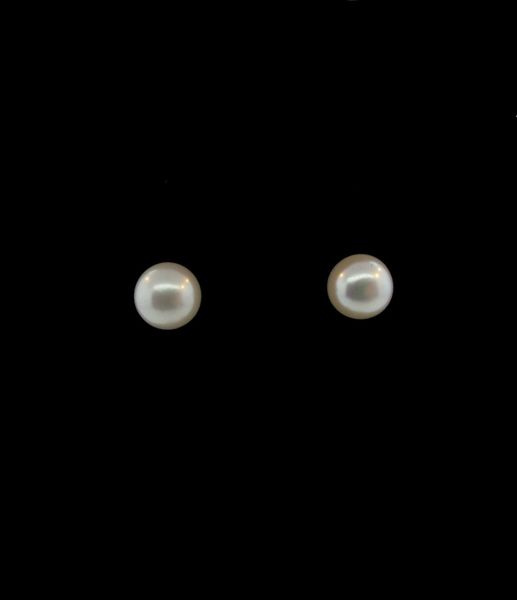 A pair of Super Silver Shell Pearl Studs on a black background, crafted in Sterling Silver.