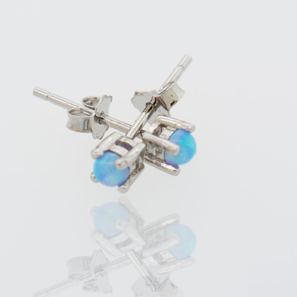 A pair of Super Silver Cultured Opal Stud Earrings featuring Lab-Created Opal on a white surface.