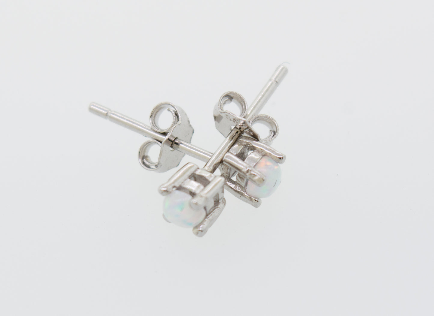 
                  
                    A pair of Super Silver Cultured Opal Stud Earrings featuring lab-created opal on a white surface.
                  
                
