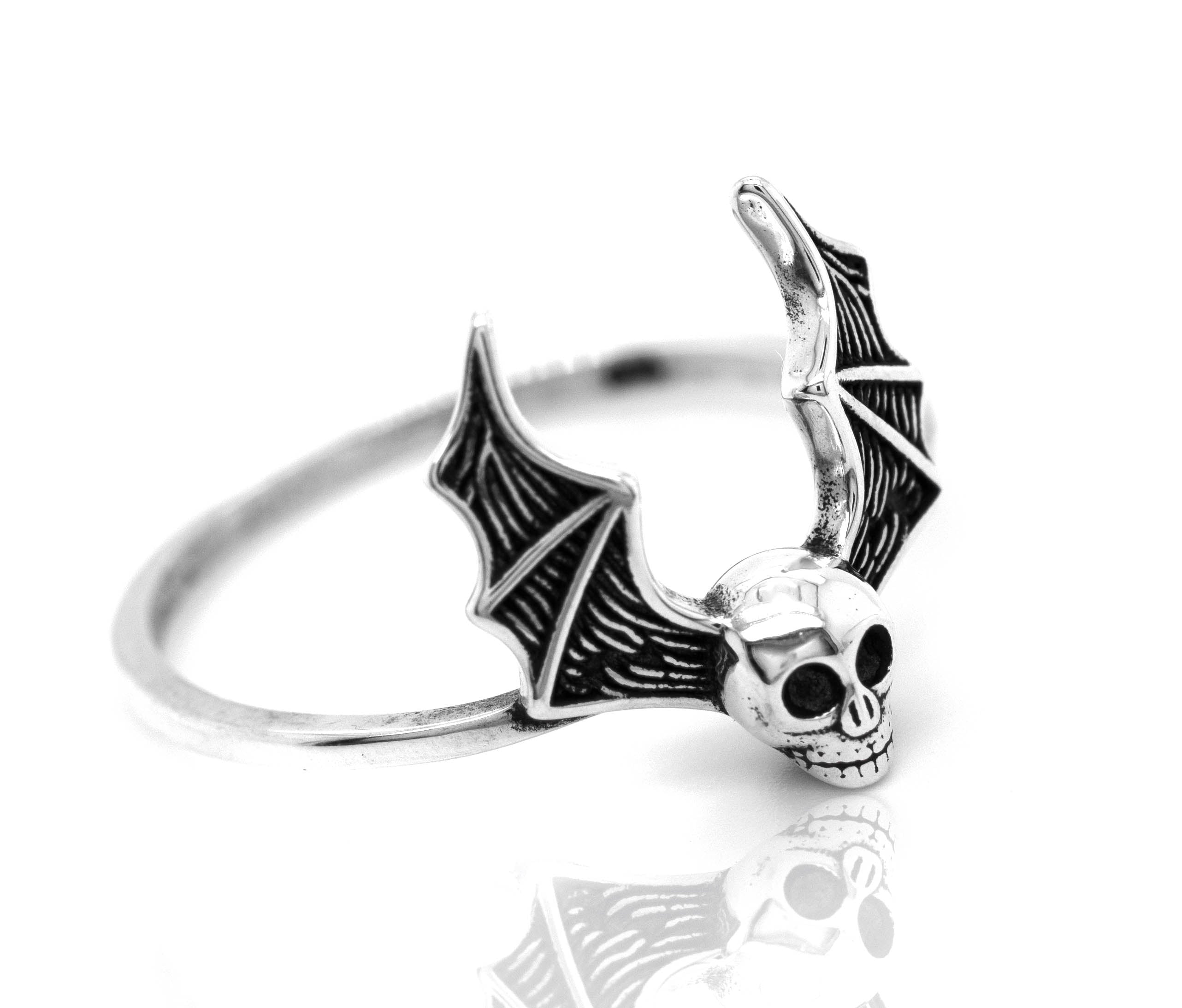A gothic sterling silver Skull Bat Ring with a skull on it.
