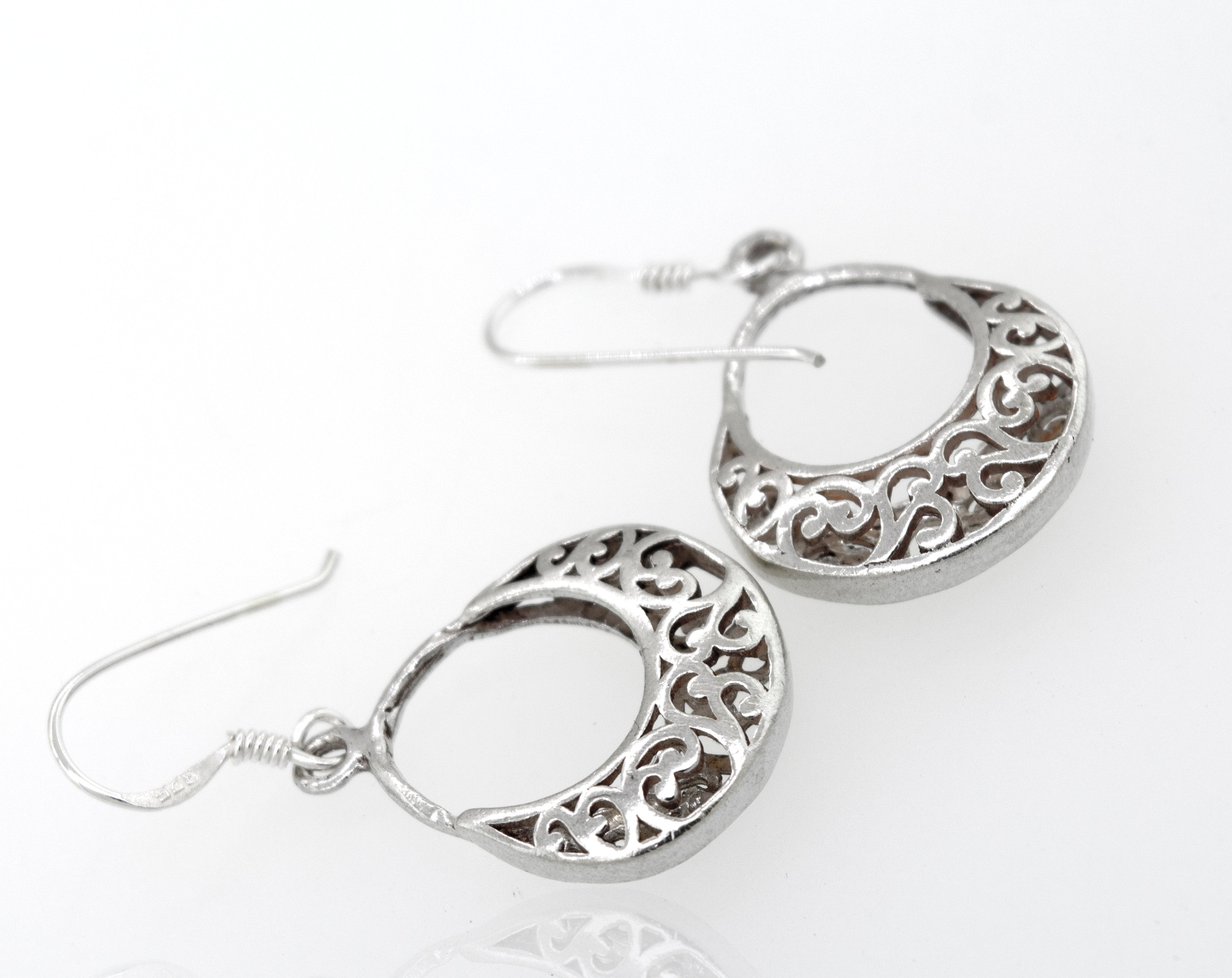 Crescent Filigree Drop Earrings in sterling silver feature intricate openwork scroll designs on a white background.