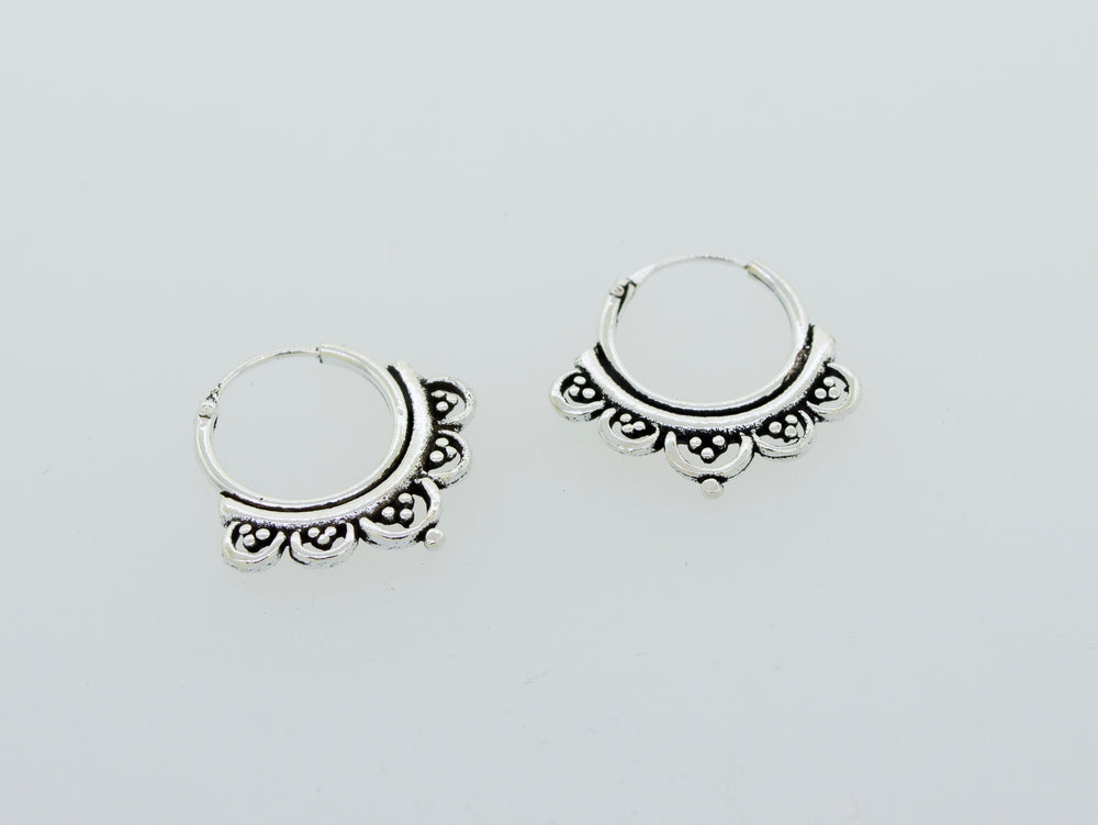 A pair of Small Beautiful Freestyle Hoop Earrings by Super Silver on a white background.