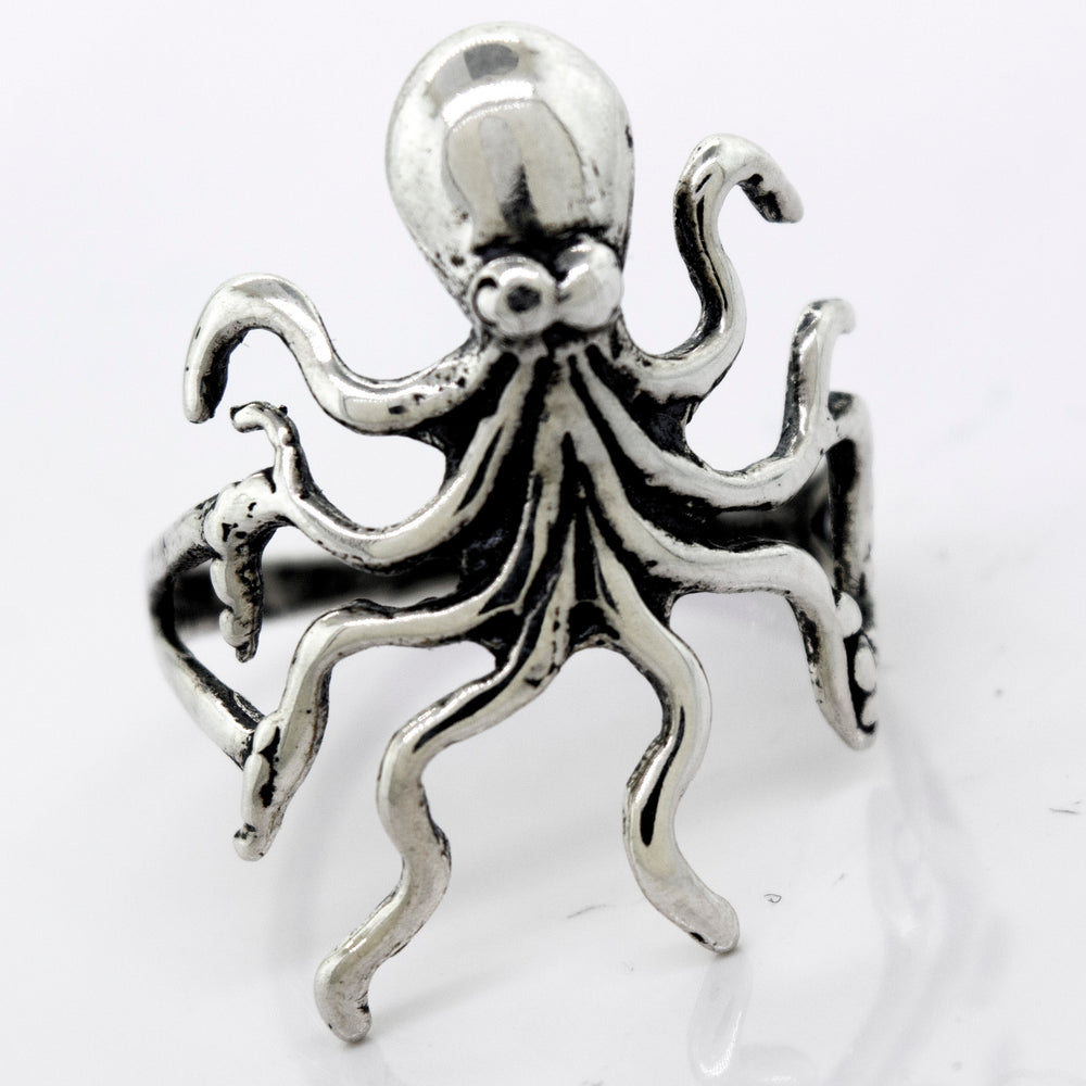A Super Silver American Made Octopus Ring on a white surface.