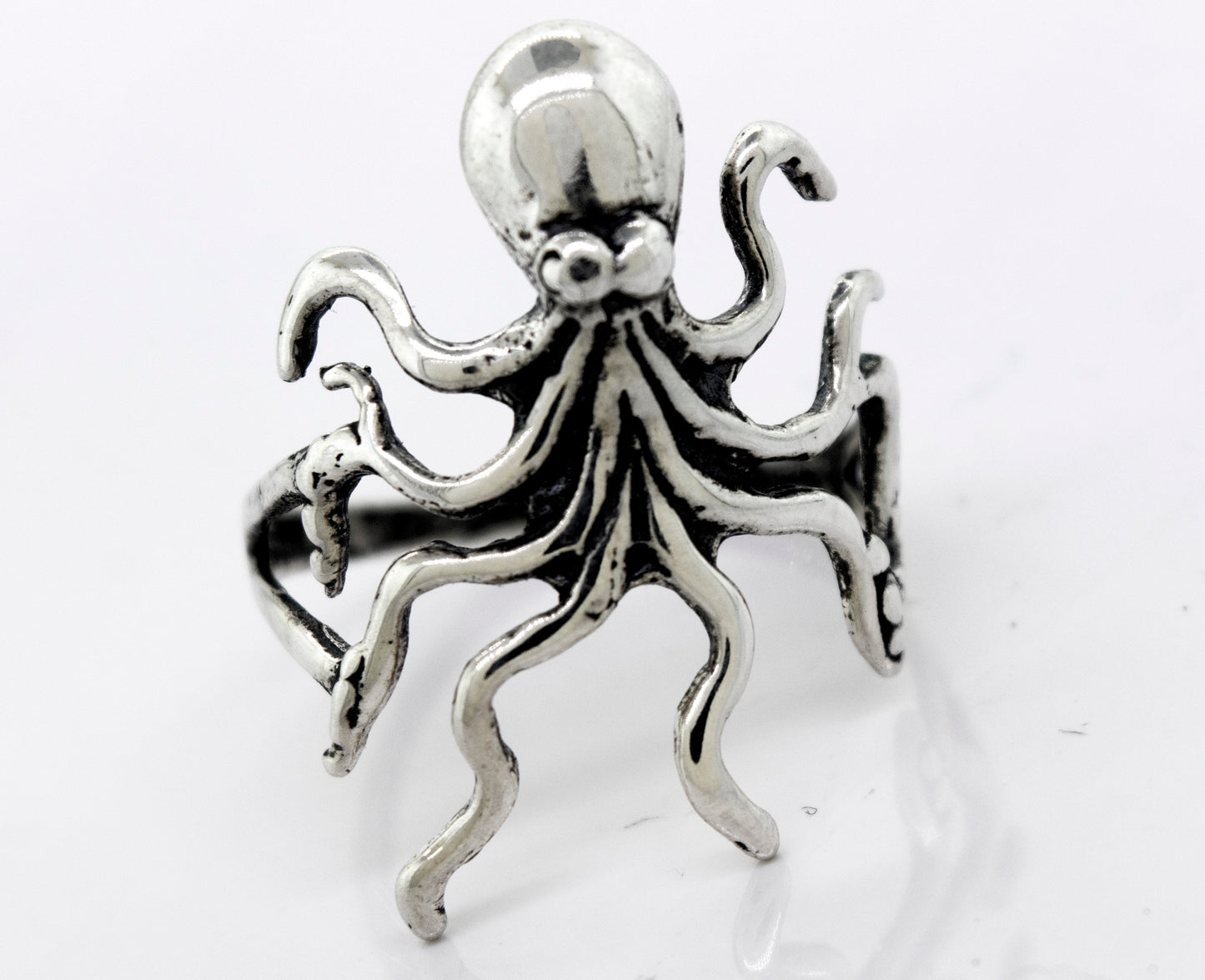 A Super Silver American Made Octopus Ring on a white surface.