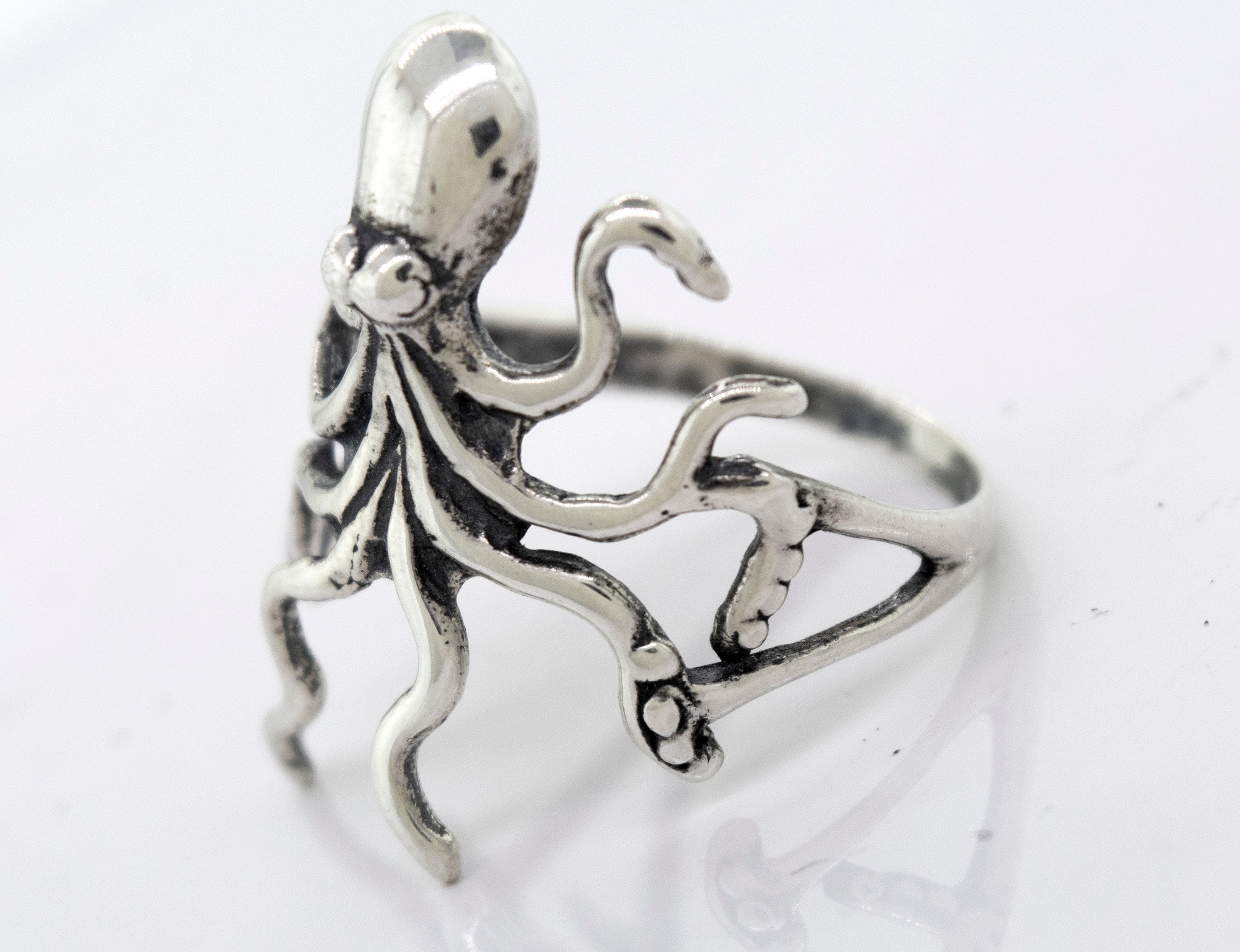 A handmade American Made Octopus Ring by Super Silver on a white surface.